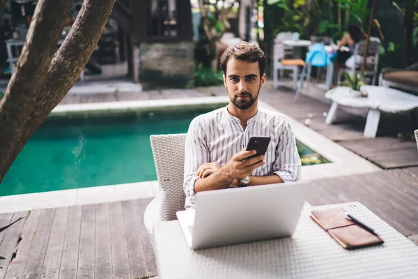 Jovem Blogueiro Masculino Roupas Casuais Usando Smartphone Olhando Para Câmera — Fotografia de Stock