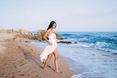 Güzel gülüşü olan neşeli bir kız Filipinler 'de tek başına geçirdiği tatillerde sahil şeridi gezintisinin tadını çıkarıyor. Uluslararası seyahatler sırasında eğlenen mutlu bir bayan turist.