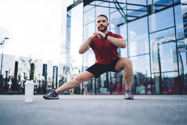 Marknivå Muskulös Idrottsman Röd Tröja Tittar Bort Och Gör Stretching — Stockfoto