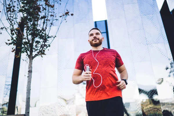 Från Positiv Skäggig Man Bär Sportkläder Lyssna Musik Medan Jogging — Stockfoto