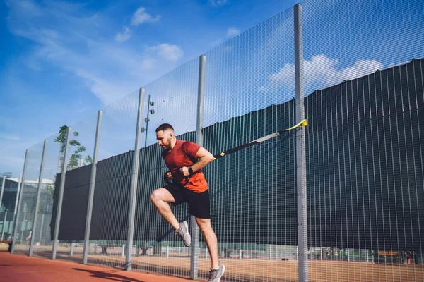 Von Unten Läuft Ein Junger Sportler Mit Federbeinen Und Schaut — Stockfoto