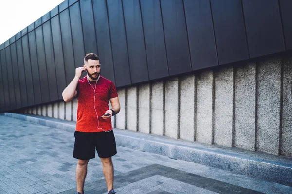 Concentrated Bearded Sportsman Sportswear Wearing Headphones Listening Songs While Standing — Stock Photo, Image