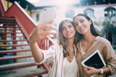 Şehir merkezinde boş zamanlarında internet blogu çeken neşeli blogcular, açık havada cep telefonu kamerası kullanan mutlu kadınlar, akıllı telefon filtreleriyle selfie içeriği oluşturdukları için 4G 'ye bağlanan mutlu kadınlar.