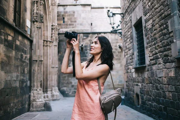 Mulher Sorridente Segurando Câmera Nas Mãos Tirando Foto Fundo Edifícios — Fotografia de Stock