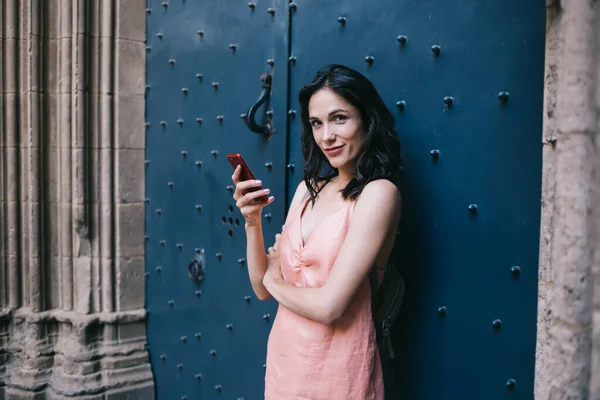 Kendine Güvenen Bir Kadın Gülümseyip Kameraya Bakarken Akıllı Telefona Bakıyor — Stok fotoğraf