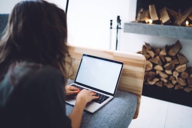 Kafkas kadın serbest yazarının evden, arka planda çalışan bir kadının dizüstü bilgisayar kullanarak ekranı taklit edişinin görüntüsü, blog paylaşımı için makale yayınlaması.