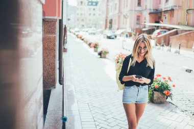Kafkasya 'nın milenyum turist kolaçan uygulaması seyahat bilgileri ile şehir caddesinde yaz yürüyüşünün keyfini çıkartıyor, sosyal ağlardan takipçilerle cep telefonu internet kullanarak neşeli kadın mesajlaşmaları