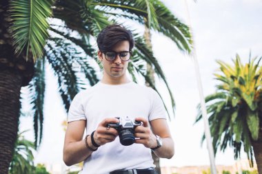 Moda kıyafetli ciddi bir beyaz adam şehir merkezinde amatör fotoğraflar çekerek boş vakitlerini harcıyor. Düşünceli 20 'li yaşlarda erkek turist kameralarla mekanları ve varış yerlerini araştırıyor.
