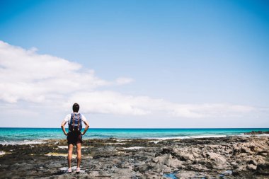 Sırt çantalı erkek turist, Menorca sahil şeridinin güzelliğine tapan sırt çantalı genç sırt çantalı gezgin, yaz tatillerini cennet ortamını yeniden canlandırmak için geçiriyor.