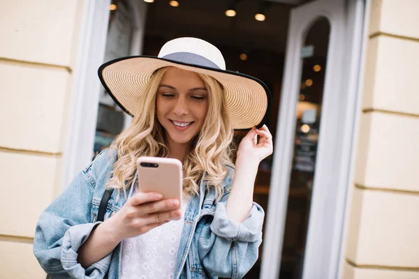 Mulher Encaracolada Loira Encantadora Chapéu Elegante Roupas Surfando Celular Mão — Fotografia de Stock