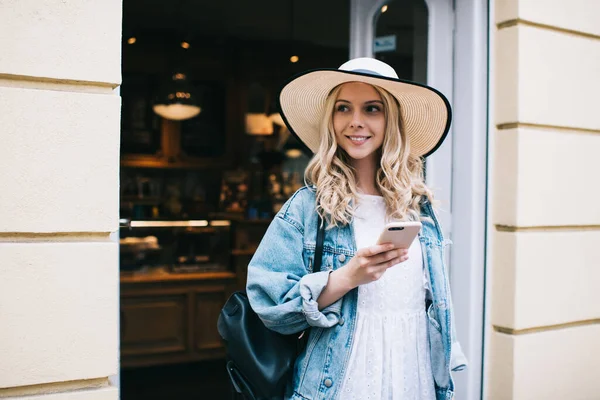 Curly Blonde Woman Denim Jacket Stylish Hat Backpack Looking Away — Stock Photo, Image