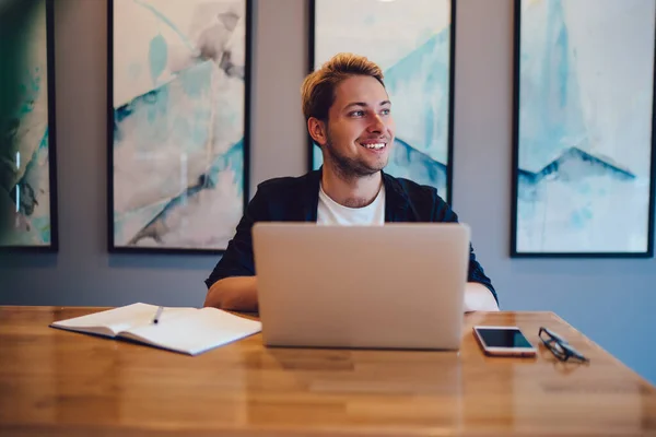 Jovem Feliz Roupa Casual Sorrindo Olhando Para Longe Enquanto Sentado — Fotografia de Stock