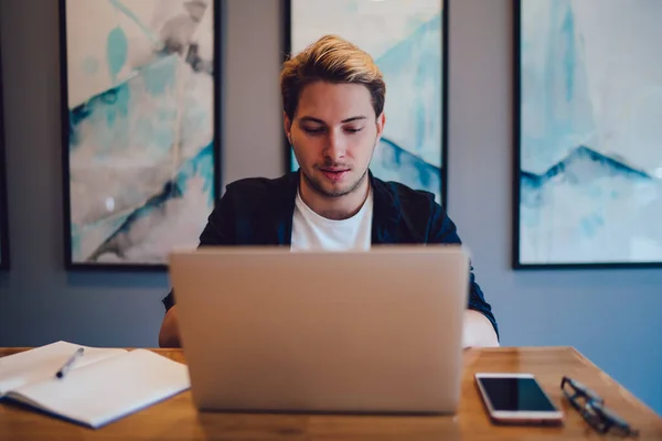 Hombre Joven Ropa Casual Escribiendo Teclado Del Ordenador Portátil Mientras —  Fotos de Stock