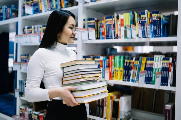 Siyah Saçlı Beyaz Bluzlu Gözlüklü Genç Asyalı Bir Kadın Kütüphanede — Stok fotoğraf