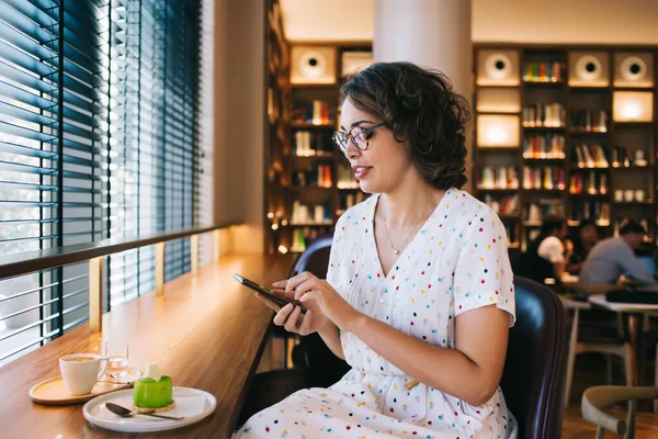 Junge Frau Brille Und Hellem Kleid Surft Handy Während Sie — Stockfoto