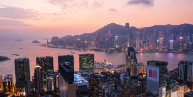 Gün batımında Victoria Limanı metropolitan körfezi ile Hong Kong Akşamı 'nın hava manzarası. Aydınlatılmış Modern şehir manzarası, şehir silueti binaları. Enerji güç altyapısı. Popüler Asya şehri