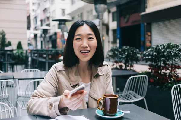 Nöjd Asiatisk Kvinna Casual Kläder Med Hjälp Smartphone När Sitter — Stockfoto