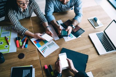 Ofis malzemeleri ve belgelerle aynı masada oturan ve boş ekran akıllı telefonlar ve dizüstü bilgisayarlarla çalışan...