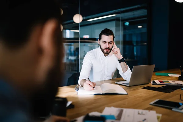 Konzentrierter Ernster Bärtiger Manager Der Notizen Schreibt Während Mit Laptop — Stockfoto