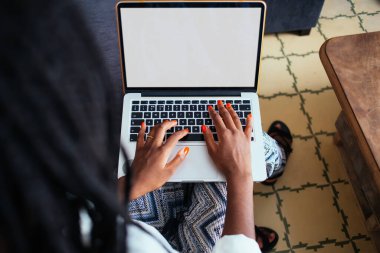 Uzaktan iş iletişimi için dizüstü bilgisayar kullanan bir kadının kesilmiş görüntüsü. İnternet sayfası klavyesinde koyu tenli bir kadın milenyum daktilosu. Bilgi tarama ve arama.
