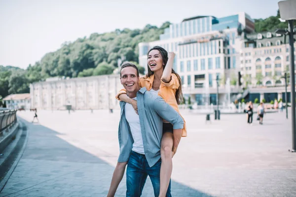 Jovem Feliz Carregando Namorada Animada Nas Costas Enquanto Caminham Desfrutam — Fotografia de Stock