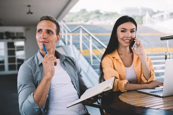 Smilende Mann Som Sitter Med Notatbok Ser Bort Mens Glad – stockfoto