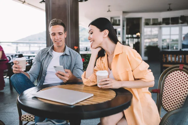 Sorrindo Homem Relaxado Com Xícara Café Mostrando Smartphone Para Rir — Fotografia de Stock