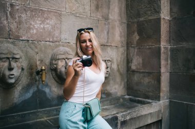 Eski mimarinin yanında eski moda ekipmanlarla güzel kadın fotoğrafçıların yarım boy portresi yalnız tatillerin tadını çıkarıyor, klasik teknolojili kaygısız hippi kız kameraya gülümsüyor.