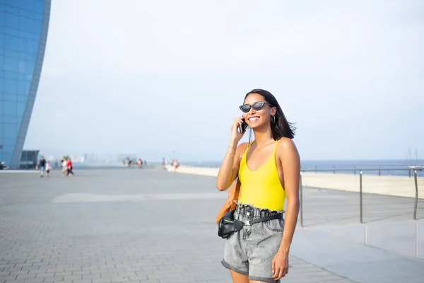 Vrolijke Etnische Vrouw Trendy Kleding Zonnebril Met Gesprek Mobiele Telefoon — Stockfoto