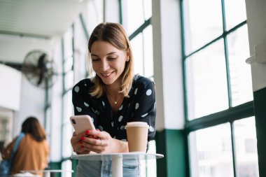 Kafkasyalı kadın nüfuzlu biri sosyal ağları araştırıyor ve boş zamanlardaki kafede cep telefonuyla videolar çekiyor, mutlu bir kadın akıllı telefonuyla internet üzerinden kahve servisi hakkında olumlu geri bildirim gönderiyor.