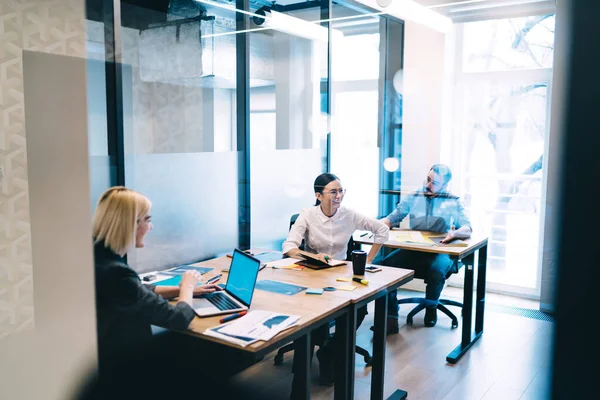 Través Vidrio Elegantes Empleados Adultos Discutiendo Riendo Mientras Sienta Escritorio — Foto de Stock