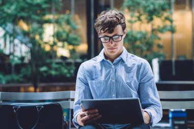 Modern dijital tabletteki 4G internete bağlı finansal web sitesinden para transferini kontrol eden Kafkasyalı zeki bir tüccar, klasik gösterilerde yatırımcılarla sohbet eden zeki bir adam.