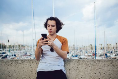 Web günlüğü sırasında günlük giysiler giyip e-posta gönderen yakışıklı bir yenilikçi. Medya içeriğini cep telefonu uygulamasına aktarmak için 4g 'ye bağlanan genç hipster kullanıcısı.