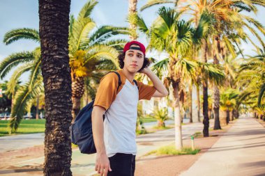 Güneşli caddede palmiye ağaçlarıyla durup yaz tatillerinde gezen gezgin, gezgin gezgin, gezgin, gezgin, gezgin, gezgin, gezgin...