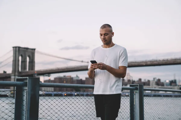 Joven Hombre Étnico Ropa Deportiva Escuchando Música Los Auriculares Utilizando — Foto de Stock