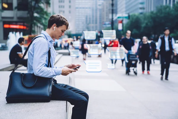 ニューヨークの路上に座って電話での正式な摩耗やワイヤレスヘッドフォンメッセージングの現代人の側面図 — ストック写真