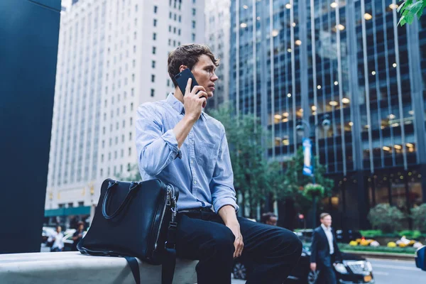 Deri çantalı genç ve ciddi bir işadamı dışarıda oturuyor ve internet bağlantısını kullanarak şehir merkezinde buluşmak için ortak arıyor, deneyimli bir avukat arıyor.