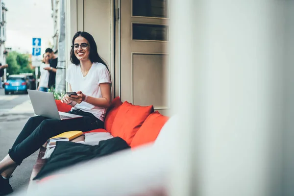 Portret Szczęśliwej Studentki Stylowych Okularach Siedzącej Wygodnej Sofie Chodniku Uśmiechniętej — Zdjęcie stockowe