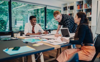 Çeşitli iş arkadaşları kağıt üzerine yaratıcı proje geliştiriyor ve şık bir ofiste otururken çalışma süreci hakkında sohbet ediyorlar.