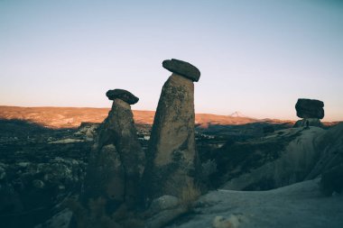 Gün batımında vadinin gölgesinde mavi gökyüzünün arka planına karşı antik dev taşların manzarası.