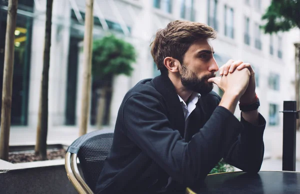 Zamyšlený Vousatý Muž Tmavé Bundě Lehké Košili Myšlení Zatímco Sedí — Stock fotografie