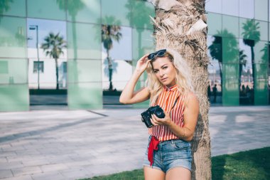 Kafkas fotoğrafçısının yarım boy portresi. Palmiye ağacının yanında dinleniyor. Hobi becerileri için haftasonu tatili yapıyor.