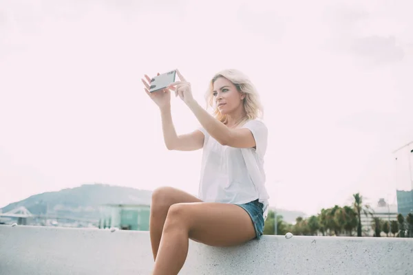 白人影响部落客在街头拍摄视频Vlog的同时 使用现代手机工具和好的相机 千禧年嬉皮士女孩通过移动应用拍摄城市风景 — 图库照片