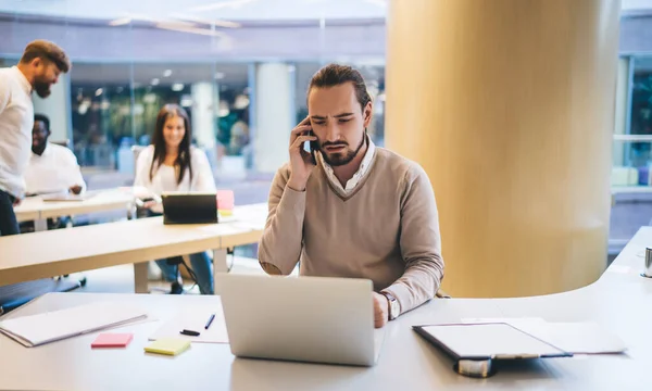 Uomo Affari Accigliato Abiti Formali Utilizzando Computer Portatile Parlando Telefono — Foto Stock