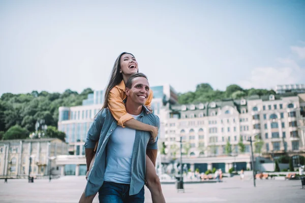 현대인이 웃으며 신나게 친구에게 피기백을 여름날 광장에서 사랑을 축하하는 — 스톡 사진