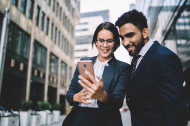 Katı siyah takım elbiseli, güler yüzlü çok ırklı iş arkadaşlarının yazın şehir merkezinde cep telefonlarında birbirleriyle sohbet etmesinden.