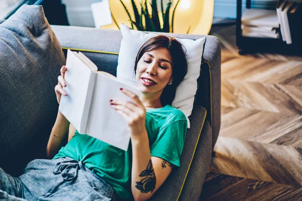 Senyum Wanita Kaukasia Tersenyum Selama Membaca Buku Menarik Berbaring Sofa — Stok Foto