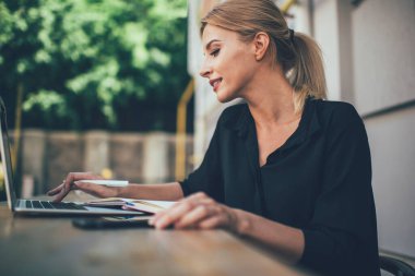 Uzaktan kumandalı kaldırımda çalışırken internet hakkında gazetecilik araştırması yapan yetenekli bir kadının modern dizüstü bilgisayarda 4G kablosuz bağlantısını kullanması, internetteki webinar rezervasyonunu yapması,