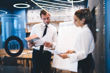 Ofiste beyin fırtınası yaparken finansal belgeleri analiz eden Kafkasyalı genç yöneticiler, başarılı erkek ve kadın uzmanlar iş stratejisi planlamak için kağıt raporlarını kontrol ediyorlar