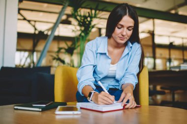 Kafkas esmer öğrenci sınav hazırlıkları için not defterine eğitim bilgisi yazıyor, zeki genç blogcu ders kitabına notlar yazarak yayın için fikirler yaratıyor.
